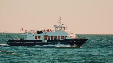 Cannes, Fransa - 18 Kasım 2025: Akdeniz XII adlı yolcu feribotunun sıcak gün batımı ışığı altında dalgalı sularda yüzüşü