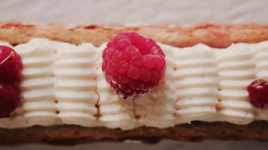 Krema, ahududu ve kırmızı frenk üzümlü bir gurme hamur işine yakın durun.