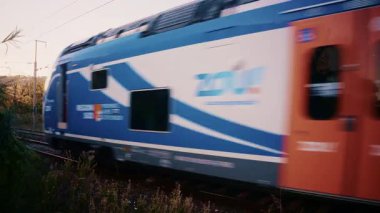 Golfe Juan, Fransa - 26 Kasım 2025: Hızlı hareket eden çift katlı bir tren, çevresindeki vahşi bitki örtüsüyle çevrili tren raylarından geçer