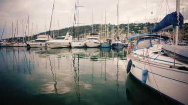 Wide shot of a marina filled with yachts and sailboats on a cloudy day in the South of France