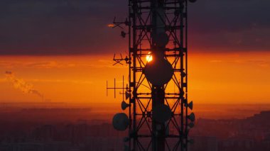 Belgrad ve Serbi üzerinde yoğun turuncu gün batımına karşı büyük bir telekomünikasyon kulesinin insansız hava aracı görüntüsü