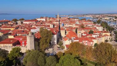 Yoğun kırmızı çatılı binaları, ortaçağ kuleleri, dar taş sokakları ve arka planda Adriyatik Denizi ile Zadar Eski Kasabası 'nın insansız hava aracı görüntüsü