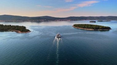 Pasman Kanalı 'nda küçük, yemyeşil adalarla çevrili bir feribot görüntüsü.
