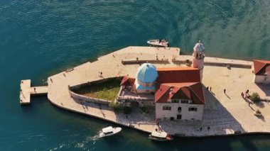 Perast yakınlarındaki Aziz George Adası 'nın hava aracı görüntüsünde taş manastırı, selvi ağaçları ve çevreleyen turkuaz su bulunuyor. Kotor Körfezi, Karadağ