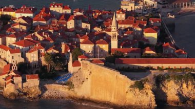 Sıcak tonlu taş çatıların ve Budva 'nın eski kasabasının dar sokaklarının insansız hava aracı görüntüsü. Karadağ