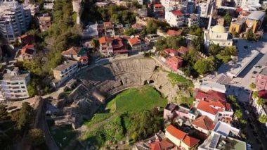 Arnavutluk 'un Durres kentindeki yerel evlerle kısmen kazılmış ve yakından çevrelenmiş olan Balkanlar' ın en büyük antik amfitiyatrolarından birinin hava aracı görüntüsü