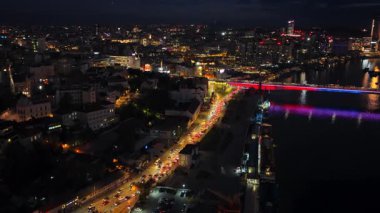 Belgrad, Sırbistan - 10 Kasım 2025: Sava Nehri ve Belgrad Rıhtımı gökdelenleri üzerindeki aydınlık köprünün insansız hava aracı görüntüsü