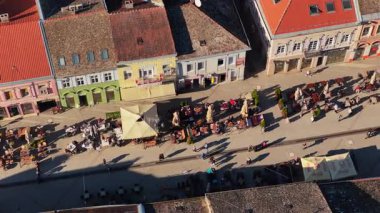 Novi Sad, Sırbistan - 12 Kasım 2025: Novi Sad 'ın açık hava kafeleri, renkli binalar ve güneşli bir günün keyfini çıkaran insanlarla dolu popüler yaya caddesinin insansız hava aracı görüntüsü