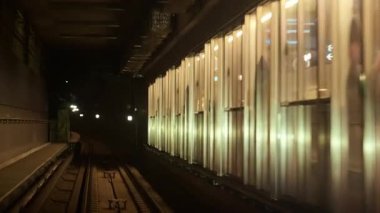 Kopenhag, Danimarka - 4 Ağustos 2025: Metro tüneli raylar boyunca dikey şeffaf paneller üzerinde soyut ışık yansımalarını gösteriyor