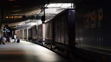 Kopenhag, Danimarka - 5 Ağustos 2025: Nakliye konteynırlarıyla dolu bir yük treni olarak bekleyen yolcular,