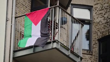 Palestine flag flying on a residential building balcony representing support