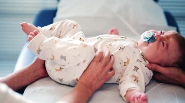 Pediatrik seans sırasında medikal ya da terapi masasında emzik takan sakin bir bebek.