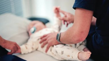 Bebek bakıcısının bacağını kaldırıp bebeğin ayağına ve arka planındaki bulanıklığa odaklanması.