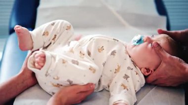 Pediatrik seans sırasında medikal ya da terapi masasında emzik takan sakin bir bebek.