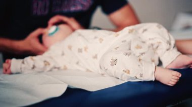 Bebek, pediatrik seans sırasında bir bakıcı tarafından nazikçe kucaklandı.