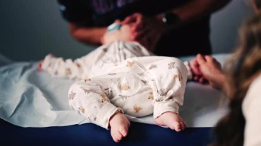 Bebek, pediatrik seans sırasında bir bakıcı tarafından nazikçe kucaklandı.