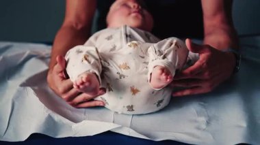 Bebek, pediatrik seans sırasında bir bakıcı tarafından nazikçe kucaklandı.