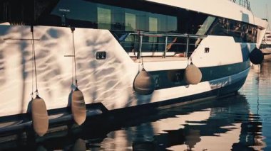 Marinada çamurluklar asılı modern lüks bir yatın gövdesini yakından görebiliriz.