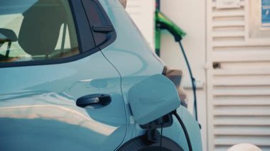 Şarj istasyonuna bağlı beyaz bir elektrikli arabayı kapat