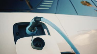 Şarj istasyonuna bağlı beyaz bir elektrikli arabayı kapat