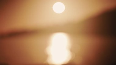 Özet olarak, Güneş 'in odak noktasından görünüşü ve deniz üzerindeki yansıması.