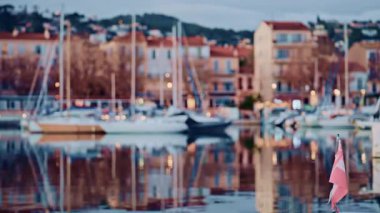 Arkalarında renkli binalarla rıhtım boyunca dizilmiş teknelerin bulanık görüntüsü.