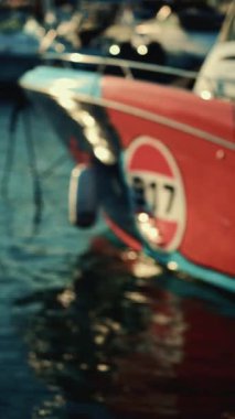 Teknenin pruvasının hafif odak noktası suya kısmen yansıyor. Dikey