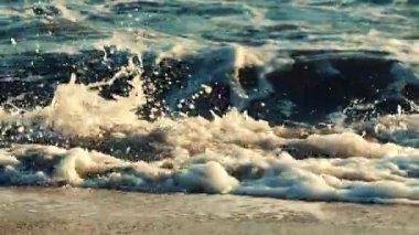 Okyanus dalgaları kıyı şeridine yaklaşırken kırılıp köpürüyor.