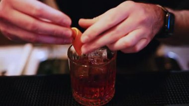 Barmen taze karışıma portakal kabuğu garnitür ekliyor.