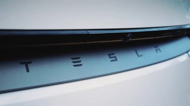 Cannes, Fransa - 23 Aralık 2025: Temiz hatları ve modern otomotiv tasarımı olan beyaz elektrikli bir aracın arkasındaki Tesla logosunu kapatın