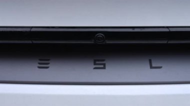 Cannes, Fransa - 23 Aralık 2025: Temiz hatları ve modern otomotiv tasarımı olan beyaz elektrikli bir aracın arkasındaki Tesla logosunu kapatın