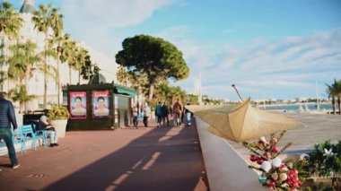 Cannes, Fransa - 23 Aralık 2025: La Croisette boyunca uzanan deniz kenarındaki korkuluklara takılmış altın Noel yıldızı süsü