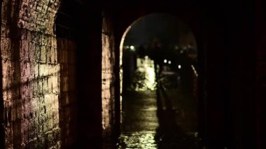 Karanlık tünel kemeri bulanık bir siluete açılıyor. Geceleri uzaklarda yürüyor. Kotor Eski Kenti, Karadağ