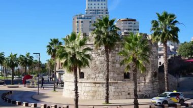 Durres, Arnavutluk - 13 Kasım 2025: Venedik Kulesi palmiye ağaçları ve modern binaların arasında duruyor