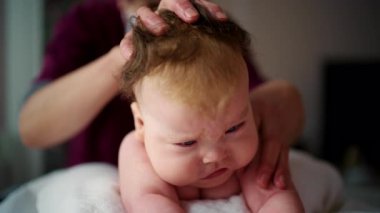 Yetişkin eller karnındayken bebeğin başını ve boynunu nazikçe destekliyor.