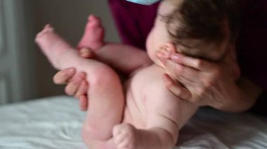 Bakıcı masaj ve bakım sırasında bebeği nazikçe kaldırır ve destekler.