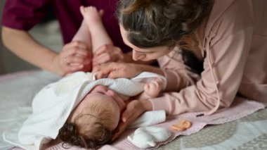 Annem masaj ve bakım seansı sırasında bebeği nazikçe yumuşak bir battaniyeye sardı.