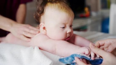 Bir bebeği kapatırken, bir yetişkin evde bakım sırasında ona nazikçe destek olur.