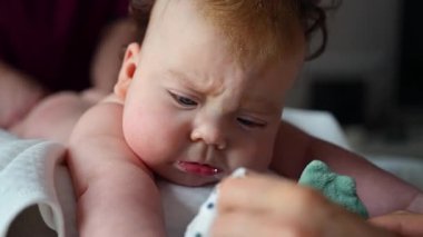 Bebek masaj sırasında renkli yumuşak oyuncaklara odaklanıyor