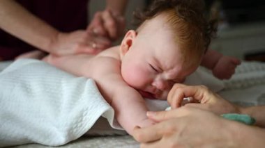 Bebek masaj sırasında renkli yumuşak oyuncaklara odaklanıyor