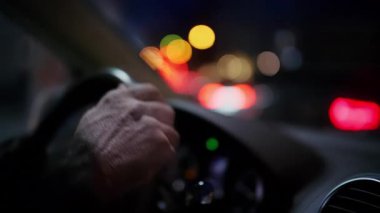 Direksiyon ve gösterge paneli görünen bir arabanın içinden gece sürücüsü sahnesi.