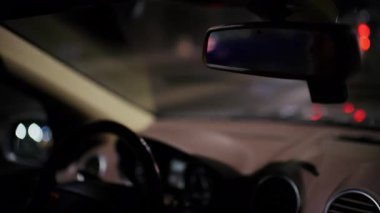 Gösterge paneli detayları ve ön cam yansımaları olan bir arabanın iç mekânının yakın perspektifini kapat