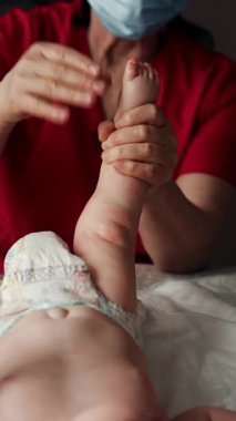 Yetişkinlerin ellerini kapat. Bebeğin ayağına ve tabanına nazikçe masaj yap.