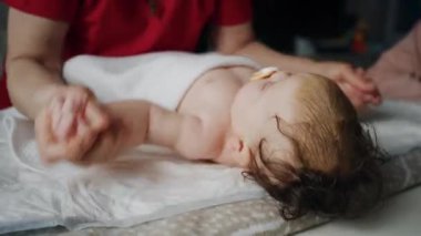 Bakıcı bebekle hareket egzersizi yapıyor.