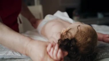 Bakıcı bebekle hareket egzersizi yapıyor.