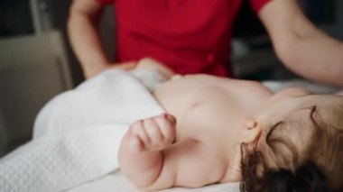 Bakıcı bebekle hareket egzersizi yapıyor.