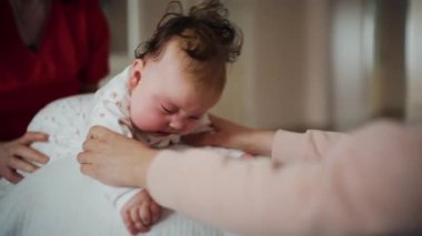Yetişkinler bebeğin gövdesini ve omuzlarını desteklerken bebek de dengeli bir topun üzerine yerleştirilir.