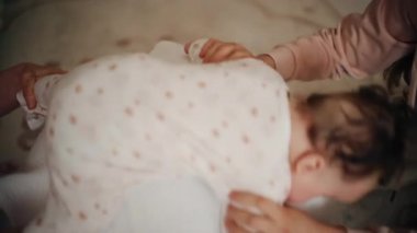 Yetişkinler bebeğin gövdesini ve omuzlarını desteklerken bebek de dengeli bir topun üzerine yerleştirilir.