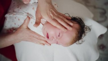 Yetişkinler bebeğin gövdesini ve omuzlarını desteklerken bebek dengeli bir topun üzerine yerleştirildi.