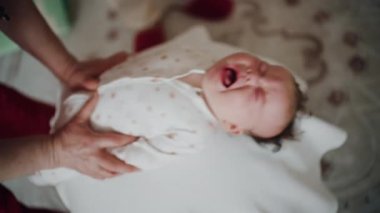 Yetişkinler bebeğin gövdesini ve omuzlarını desteklerken bebek dengeli bir topun üzerine yerleştirildi.